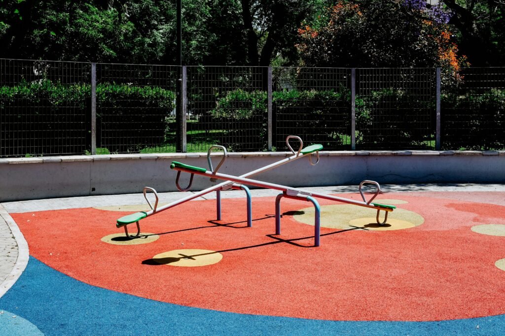 Empty seesaw in a vibrant Buenos Aires playground on a sunny day, showcasing vibrant colors and urban design.